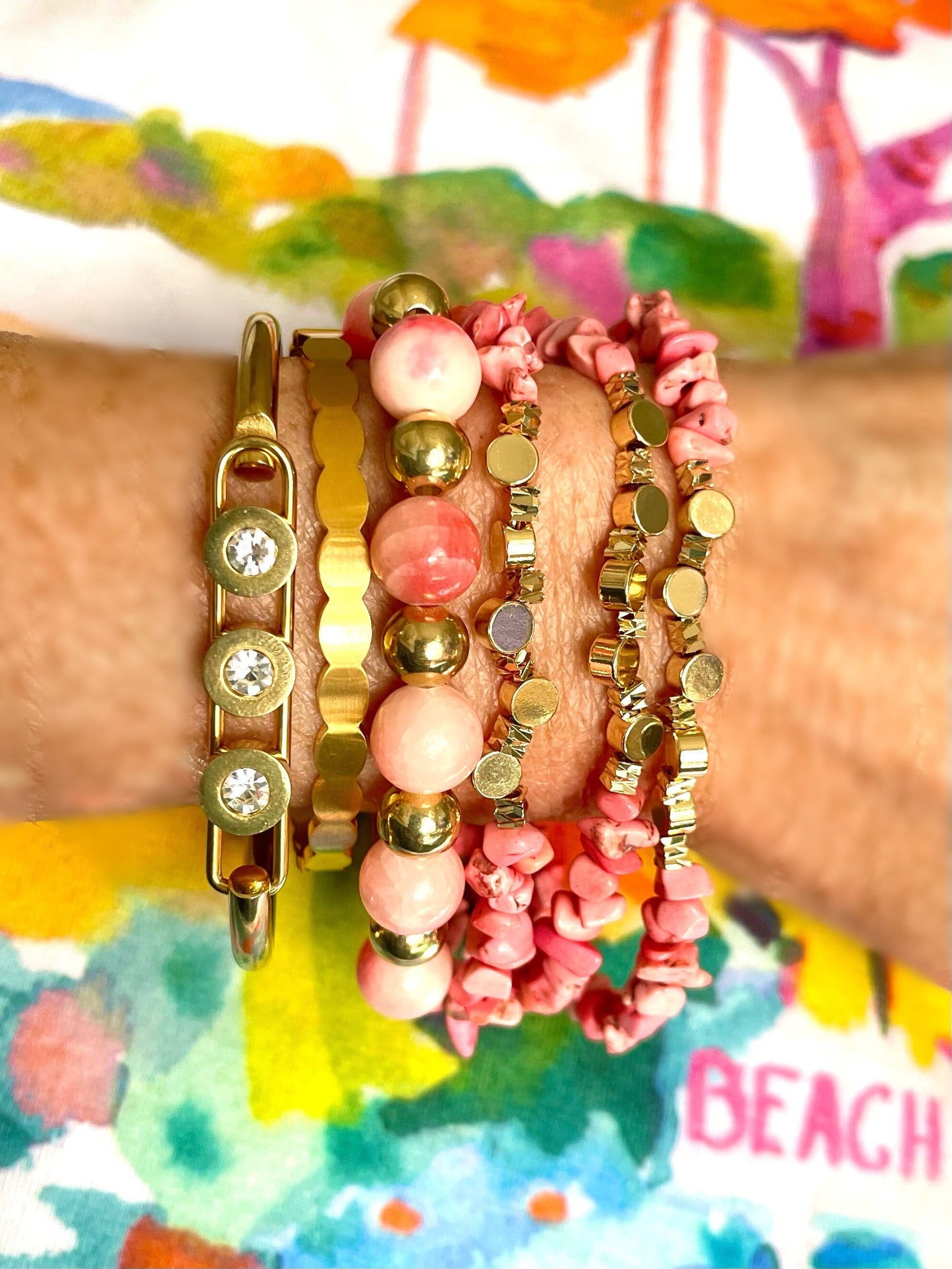 Peachy pink bracelet stack with a triple strand adjustable bracelet with nuggets of coral color howlite and gold beads.  Gold cuff